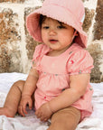 baby in a pink bodysuit made from organic cotton by purebaby organic