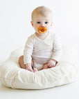 baby sitting on organic cotton bed lounger
