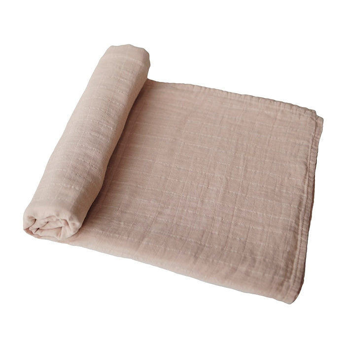 mushie organic cotton muslin swaddle blanket for baby in pale taupe