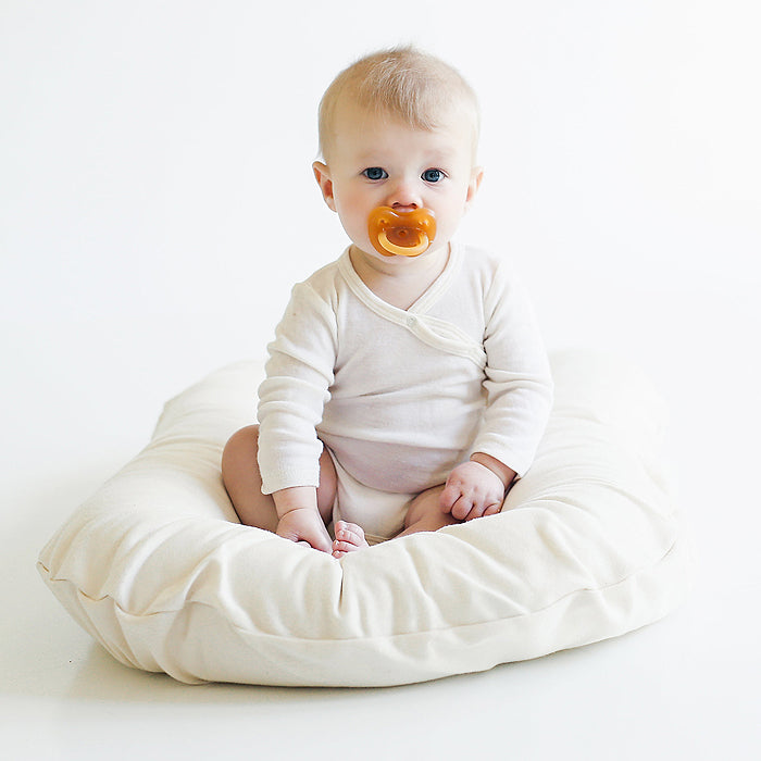 baby sitting on organic cotton bed lounger